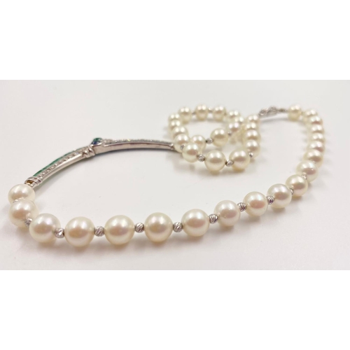 33 - A BEAUTIFULLY CRAFTED PEARL AND DIAMOND NECKLACE WITH CHANNEL SET EMERALDS AND DIAMONDS IN 18K WHITE... 
