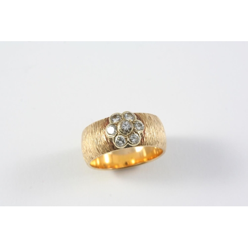 1381 - A DIAMOND AND GOLD RING the textured 18ct gold band is mounted with a diamond flowerhead cluster, 7.... 