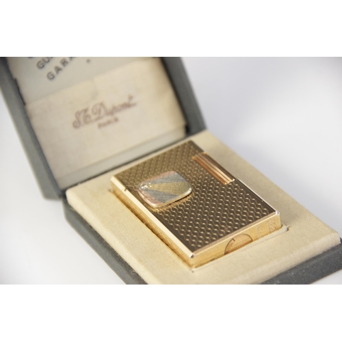 27 - A Dupont diamond set gold plated lighter, of rectangular form with engine turned decoration, applied... 