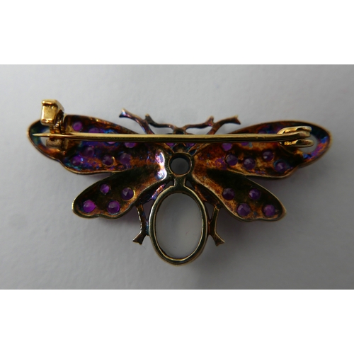 12 - A yellow gold butterfly brooch studded with rubies and four moonstone cabochons, 1.5 x 3.5cm, 3.4g
