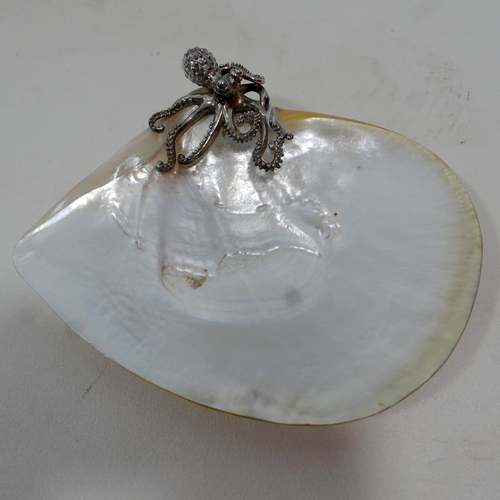 13 - A mother of pearl shell and silver mounted dish, with octopus finial, on four ball feet, marked to b... 