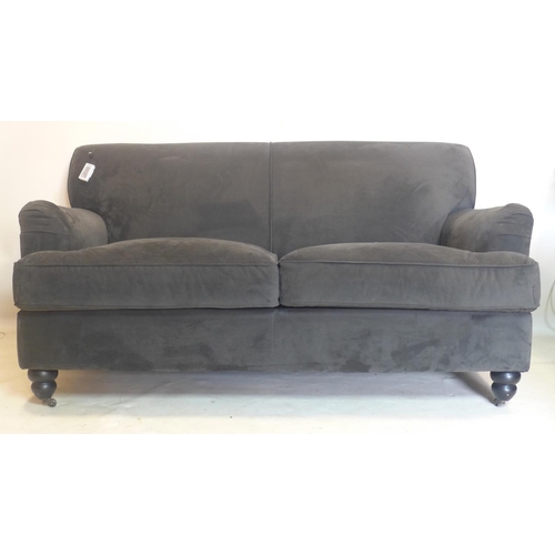 A contemporary grey velour upholstered sofa, raised on turned legs and