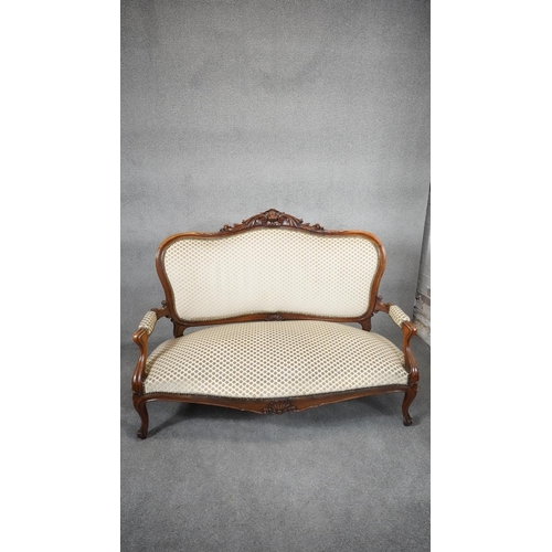 29 - A Louis XV style mahogany framed sofa with floral carved backrail in cut flowerhead upholstery raise... 