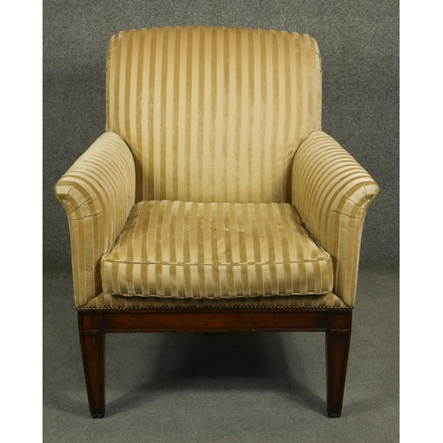 186 - A Regency style mahogany upholstered library armchair on square tapering supports and sabre supports... 