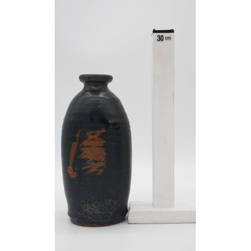 217 - A Oriental black glazed terracotta sake bottle/vase with abstract design. H.24cm