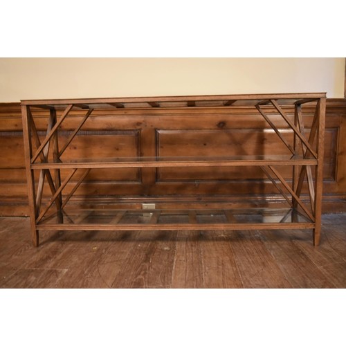 24 - An X framed teak console table with three plate glass tiers. H.72 W.140 D.33cm