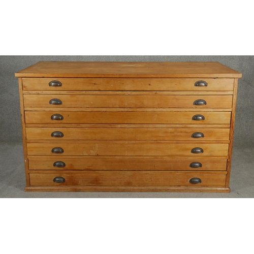 85 - A vintage pine architect's plan chest of seven drawers with brass cup handles. H.94 W.155 D.77cm