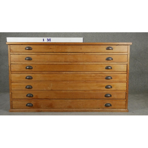 85 - A vintage pine architect's plan chest of seven drawers with brass cup handles. H.94 W.155 D.77cm