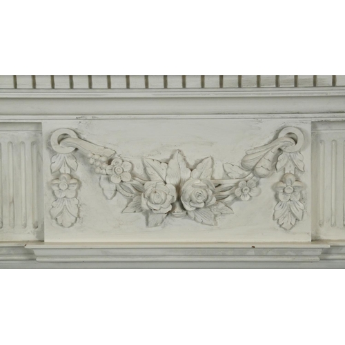 105 - A carved and painted Adam style fire surround with floral swag decoration to the frieze. H.120 W.133... 