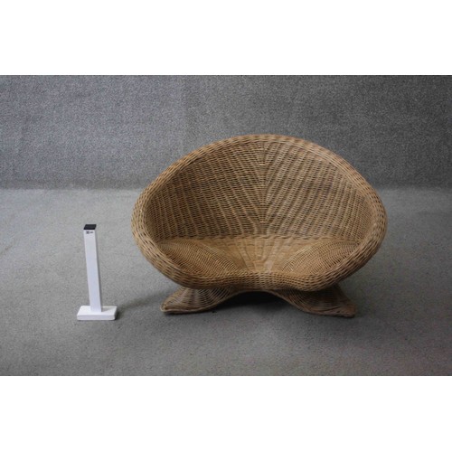 33 - A contemporary shaped wicker armchair. H.40 W.75 W.42 cm