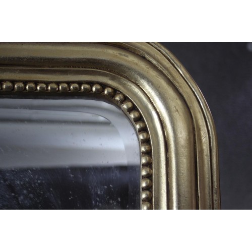 160 - A full height gilt framed pier mirror with arched plate in moulded and beaded frame with shell crest... 