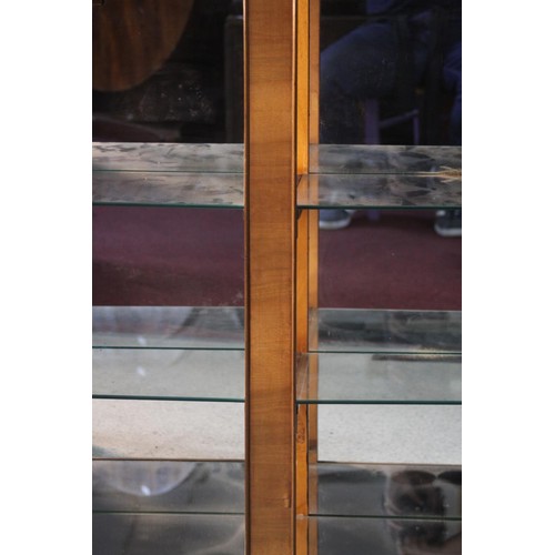 41 - An Art Deco walnut cloud shaped display cabinet with sunray astragal glazed doors on plinth base. H.... 
