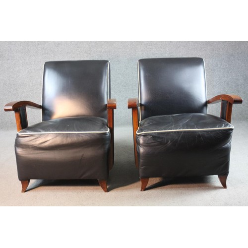 42 - A pair of mid century French Art Deco style beech framed armchairs in piped leather upholstery on sw... 