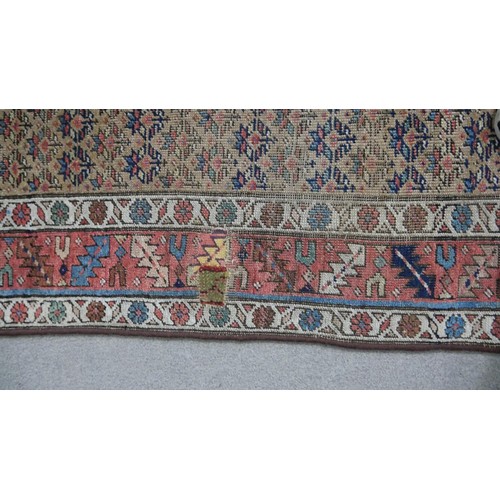 241 - A Caucasian runner with repeating stylised floral motifs across the biscuit ground within serrated p... 