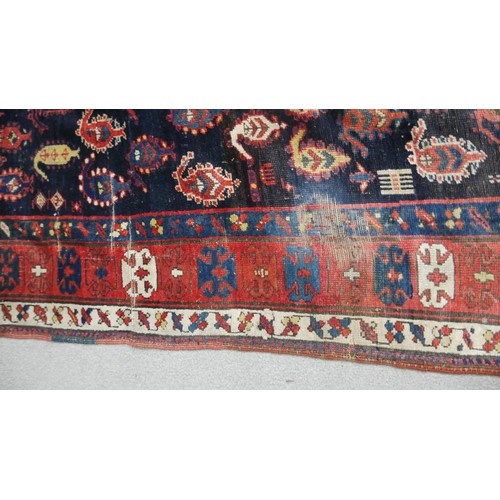 242 - A large Kurdish runner with repeating motifs across the midnight ground within stylised multiple bor... 