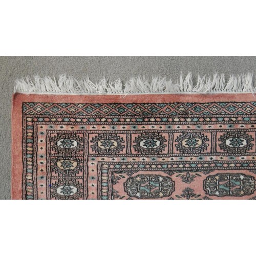 393 - A rose ground handmade Pakistan Bokhara rug. L.150 W.100cm