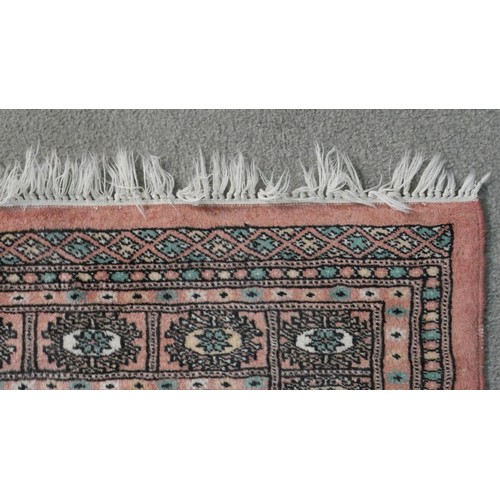 393 - A rose ground handmade Pakistan Bokhara rug. L.150 W.100cm
