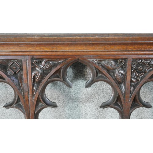 223 - A gothic revival oak wall shelf, with four arched sections, the top of each of trefil form and carve... 