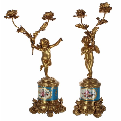 559 - Attractive pair of French porcelain and ormolu figural twin branch candelabra, modelled as putti fig... 
