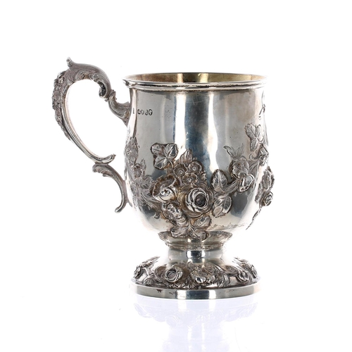 502 - Attractive Victorian repousse silver pedestal christening mug, with foliate swags and C scroll handl... 