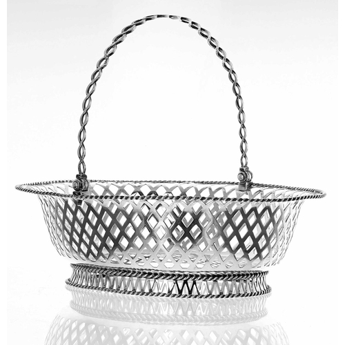 525 - Edwardian oval pierced silver basket, with a swing handle and rope twist borders, engraved crest to ... 
