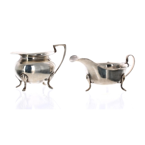 528 - Viner's Ltd. silver cream jug, with card cut shaped rim raised on three feet, Sheffield 1962, 6