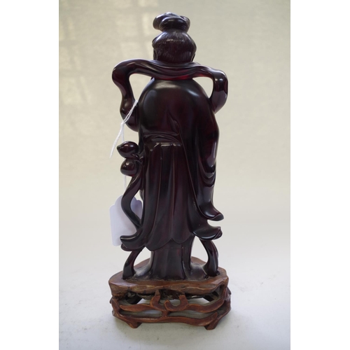 545 - A Chinese 'cherry amber' figure of Guanyin, on fitted hardwood stand, total height 24.5cm.... 