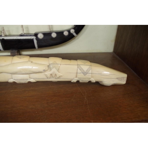 1728 - Scrimshaw: a large 19th century Inuit carved marine ivory tooth, relief carved with seals and walrus... 