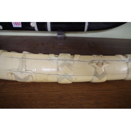 1728 - Scrimshaw: a large 19th century Inuit carved marine ivory tooth, relief carved with seals and walrus... 