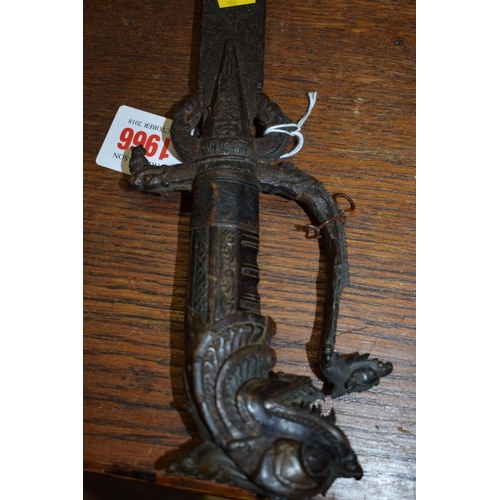 1966 - A 19th century Indonesian sword, having curved 49cm blade and carved wooden handle decorated dragon.... 