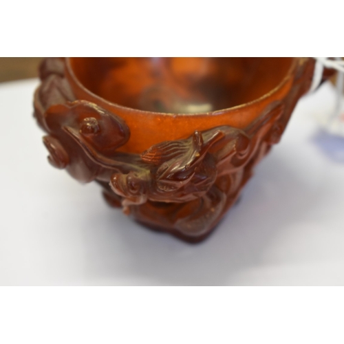 732 - A very rare Chinese carved amber libation cup, 17th century, carved in high relief with dragons and ... 