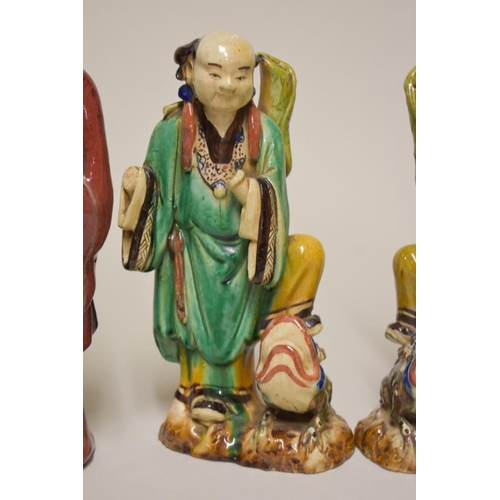 506 - Three Chinese Shiwan flambe figures, comprising: a Daoist, 30cm high; and a pair of attendants, 27cm... 