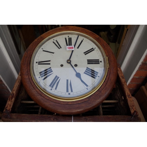 1009 - An oak circular wall clock, with 12in painted dial, with pendulum and winding key. ... 