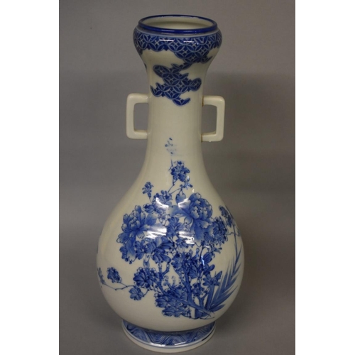 605 - A Japanese blue and white twin handled vase, painted with flowers, 35.5cm high, (one handle re-stuck... 