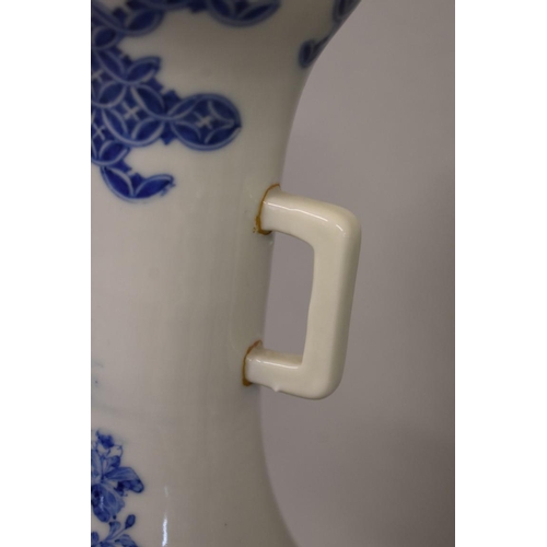 605 - A Japanese blue and white twin handled vase, painted with flowers, 35.5cm high, (one handle re-stuck... 