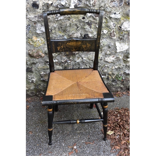 1000a - An ebonized cane seated chair, having gilt decoration.
