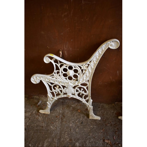 1002 - A pair of white painted cast iron bench ends, 73cm high x 60cm wide. 