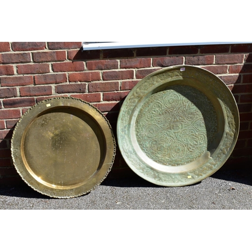1073 - A large Eastern brass tray; together with a smaller example.