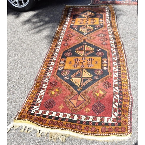 1083 - A large Afghan runner, having two central diamonds with geometric borders, 366 x 102cm.... 