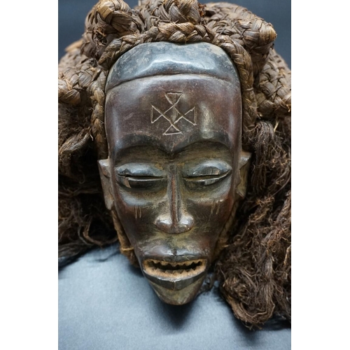 1449 - Ethnographica: a Baule tribal mask, Cote d'Ivoire, with an elaborate fibre back, 21cm.... 