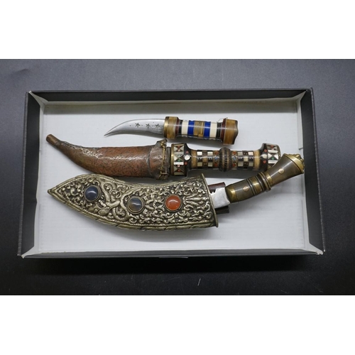 1725 - A small kukri and scabbard; together with two other eastern knives. 