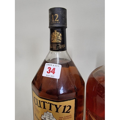 34 - Two old bottles of blended whisky, comprising: a 26 2/3 fl.oz. bottle of Cutty Sark 12 year old, 197... 