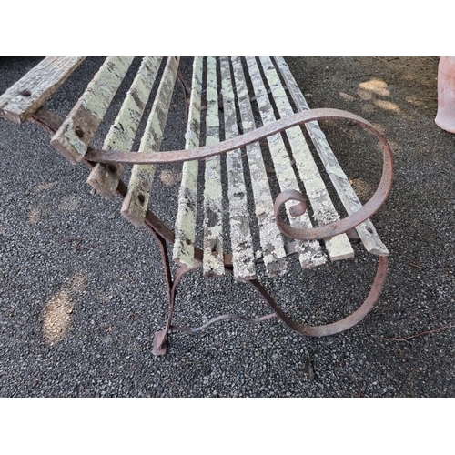 1033 - A garden bench, having wrought iron supports, 183cm wide.