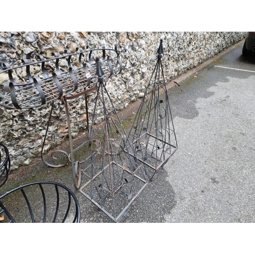 1040 - A wrought iron planter; together with a pair of black painted planters and a pair of plant obel... 