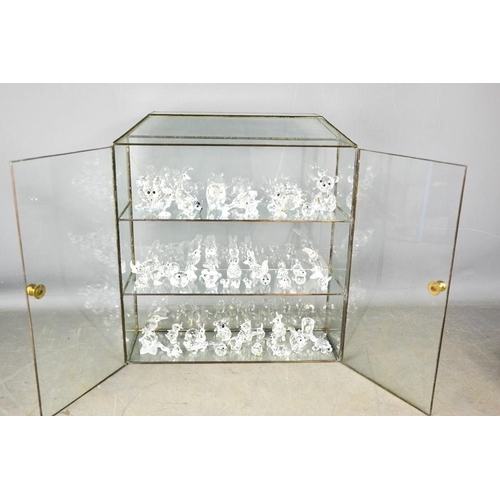vijand Barry Smederij A glass display cabinet, together with a group of Swarovski ... | Barnebys
