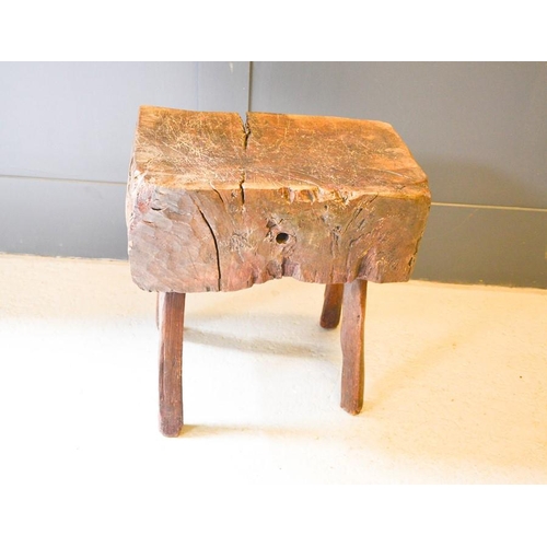 A large antique chopping block raised on splayed stick legs,... Barnebys