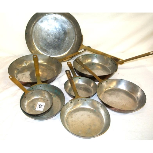 42 - Set of eight brass and copper saucepans with long handles