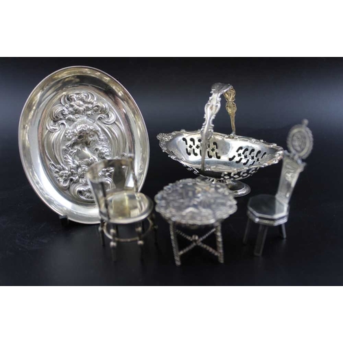 10 - A collection of silver miniatures, includes; two chairs, a table, a tray, and a swing handled basket... 