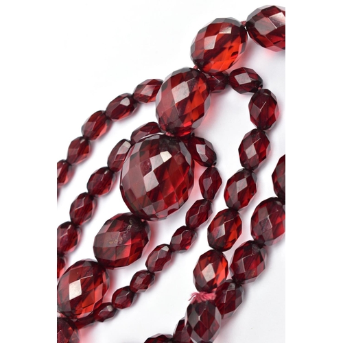 58 - TWO SETS OF FACETED CHERRY AMBER PLASTIC BEAD NECKLACES, the first designed with circular faceted be... 