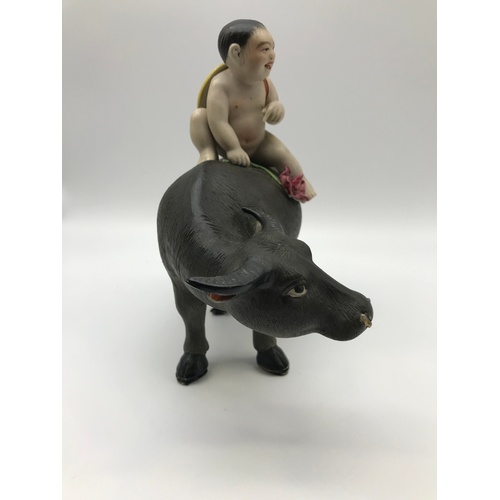 An Antique Chinese porcelain nude boy figure riding on top 